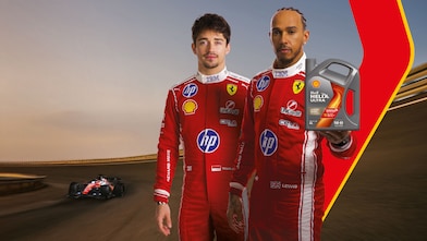 Lewis Hamilton showing a bottle of Shell Helix Ultra with Charles Leclerc standing by his side.