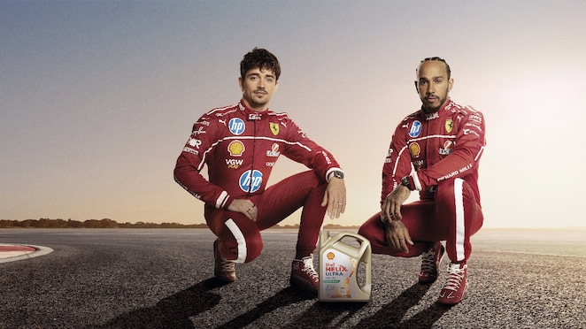 Charles Leclerc y Lewis Hamilton posan en cuclillas junto a un envase de aceite Shell Helix Ultra.