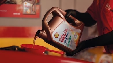 Experto cargando lubricante Shell Helix en auto