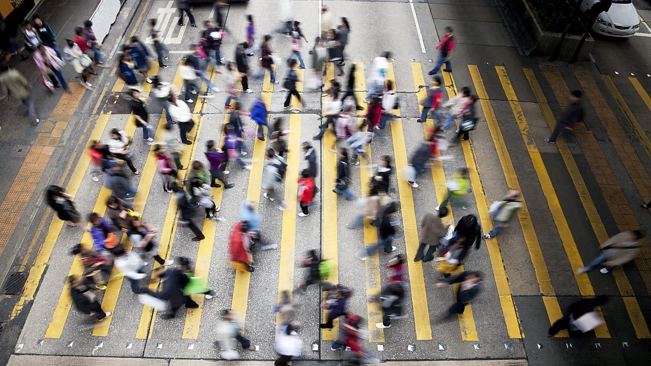 Personas cruzando una calle llena de gente en Hong&nbsp;Kong