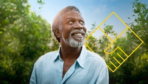 Hombre sonriente con barba frente a árboles con un gráfico de Generando valor para los accionistas