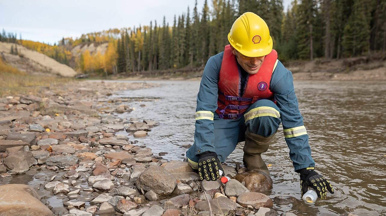 Empleado de Shell recolectando agua del río
