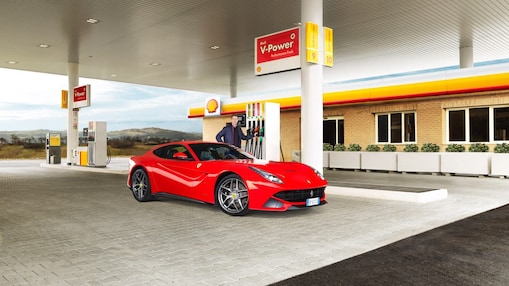 Carro Ferrari rojo en una estación de servicio Shell