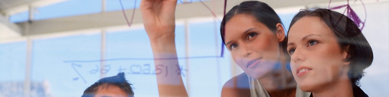 Businesswoman drawing graphs on glass