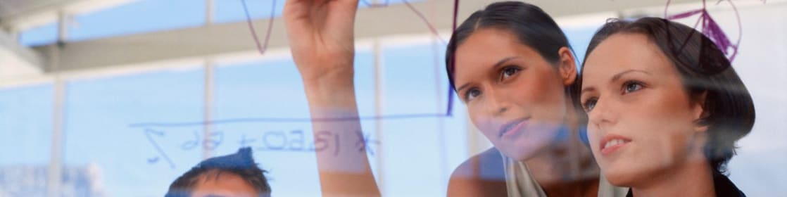 Businesswoman drawing graphs on glass