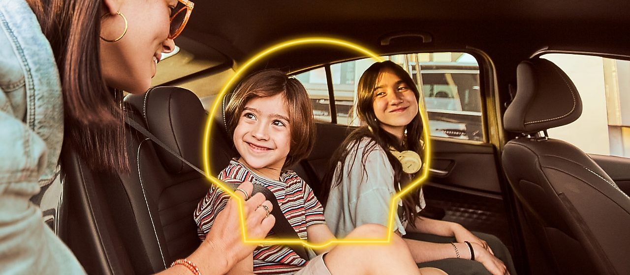 imágenes de una familia disfrutando en su auto. Están en una estación Shell y rodeados de un pecten neon.
