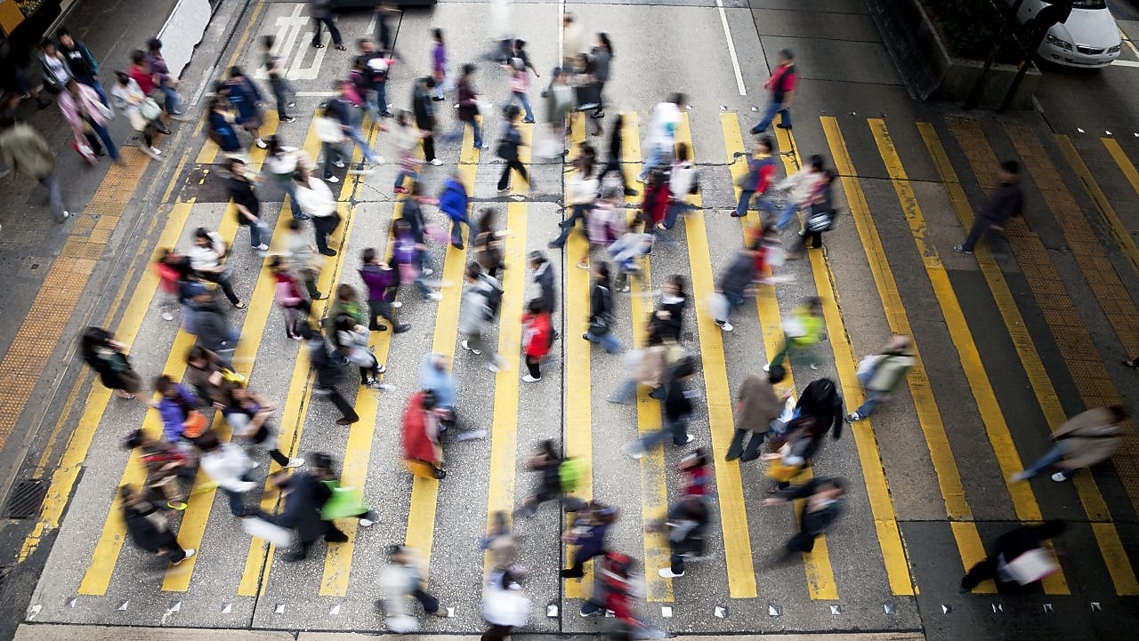 Personas cruzando una calle llena de gente en Hong Kong
