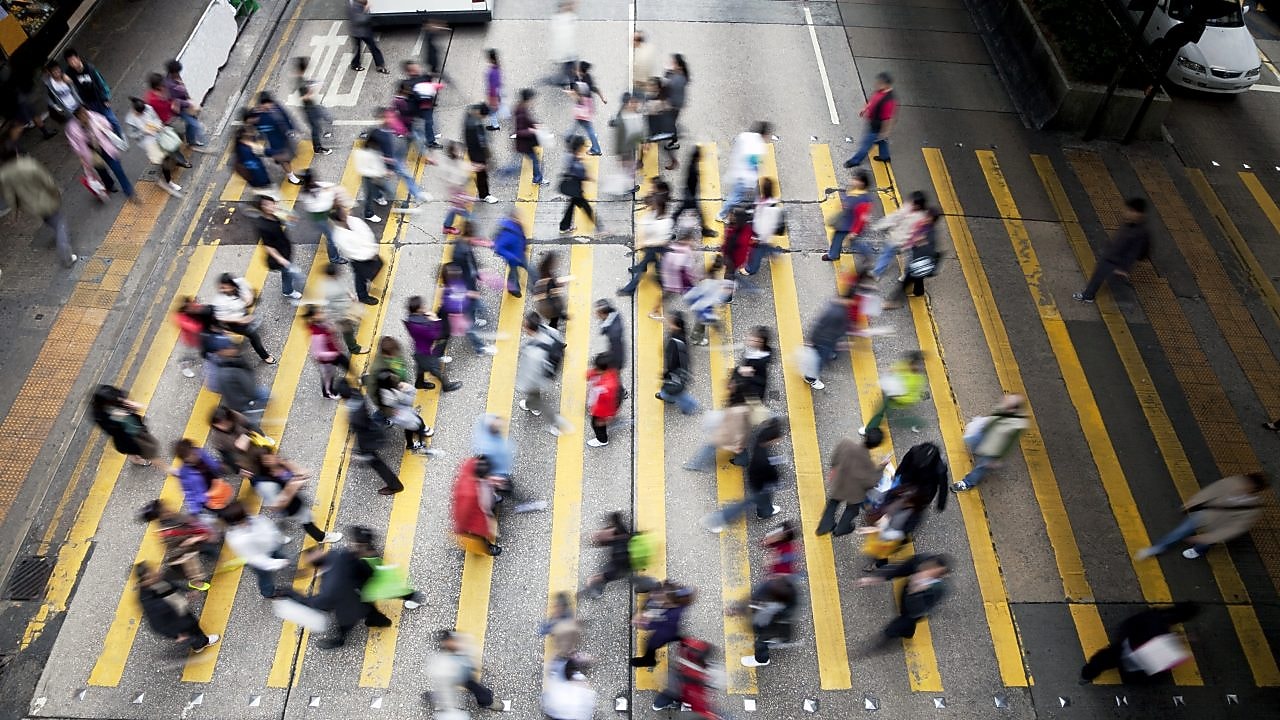 Personas cruzando una calle llena de gente en Hong&nbsp;Kong