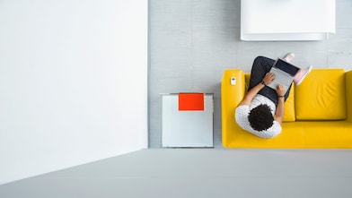 Jóven sienta en un sofa amarillo