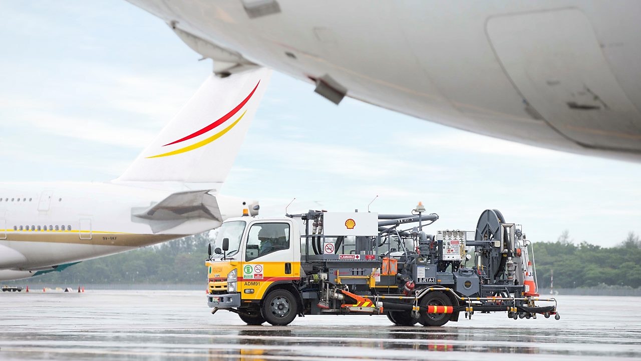 Vista de un camión de Shell a punto de cargar un avión en la pista de aterrizaje