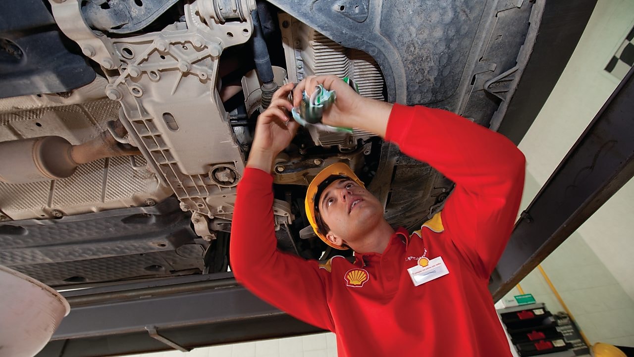 empleado ensamblando piezas en un auto