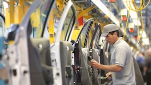 hombre sosteniendo un cable mientras mira una máquina