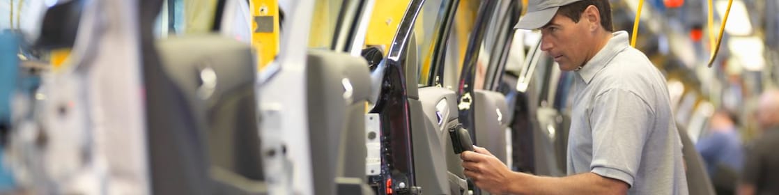 hombre sosteniendo un cable mientras mira una máquina