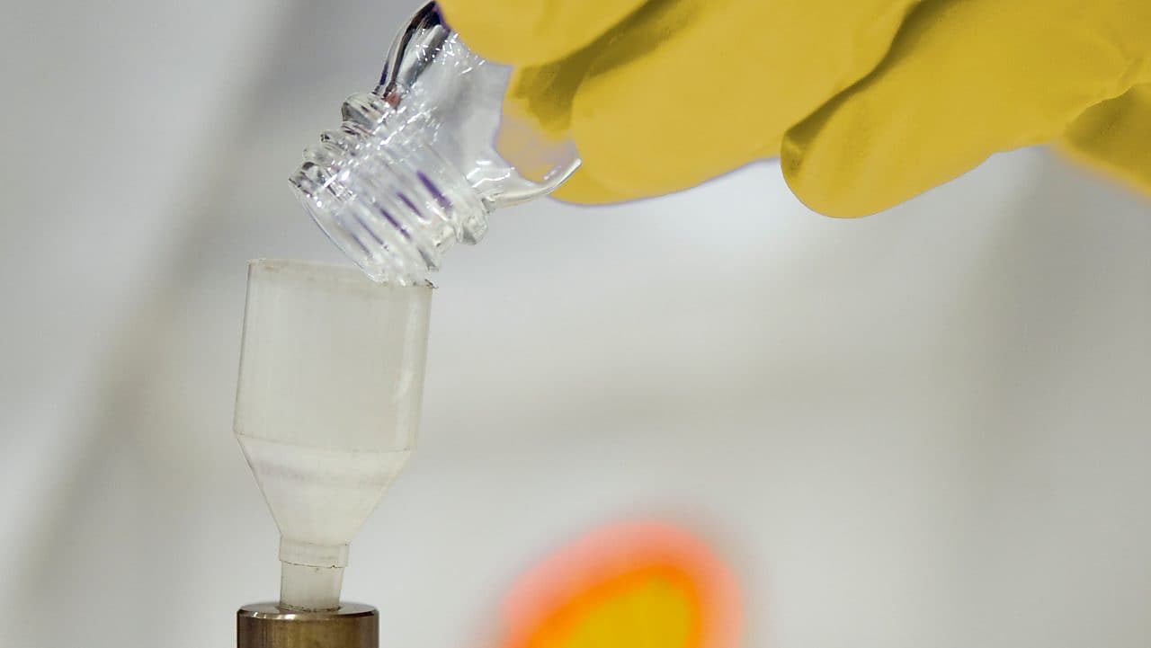 Un científico de Shell vierte líquido en un embudo de plástico en un laboratorio
