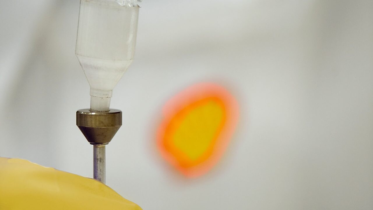 Un científico de Shell vierte líquido en un embudo de plástico en un laboratorio