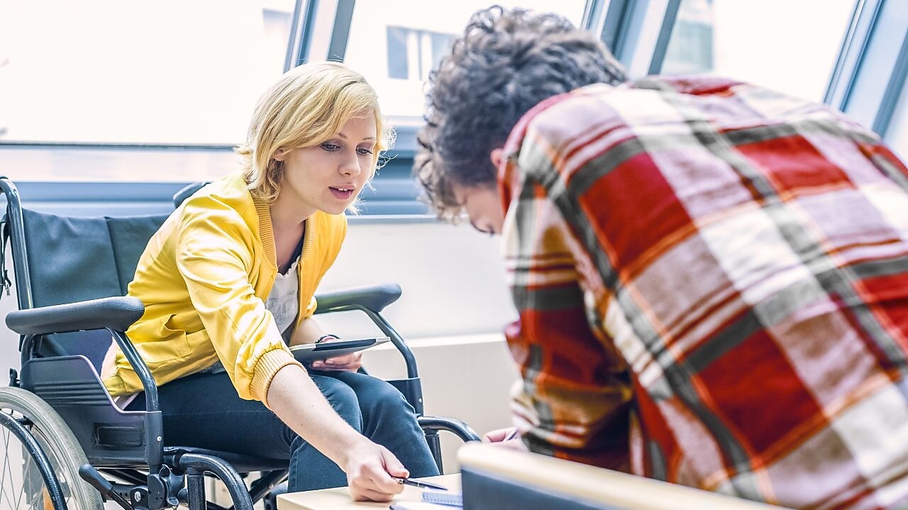 Woman in a wheelchair talking to a man