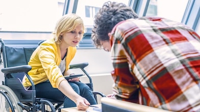 Woman in a wheelchair talking to a man