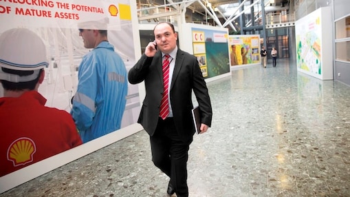 Andy Kneen walking and talking on the phone at a Shell office