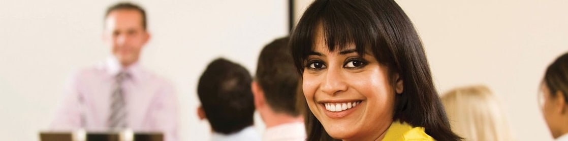 Sonriente mujer con blusa amarilla mirando hacia atrás