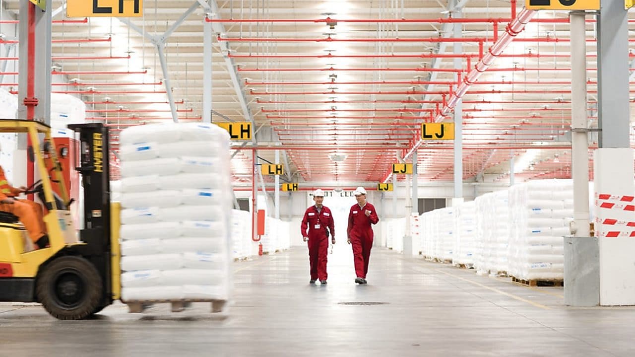 Dos empleados andando por una fábrica