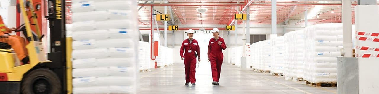 Dos empleados andando por una fábrica