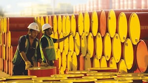 dos empleados transportando barriles de Shell