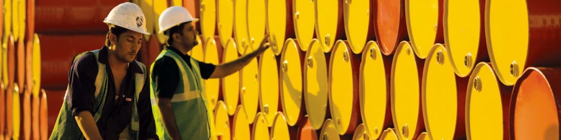 dos empleados transportando barriles de Shell