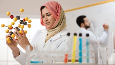 mujer con hijab examinando modelo molecular