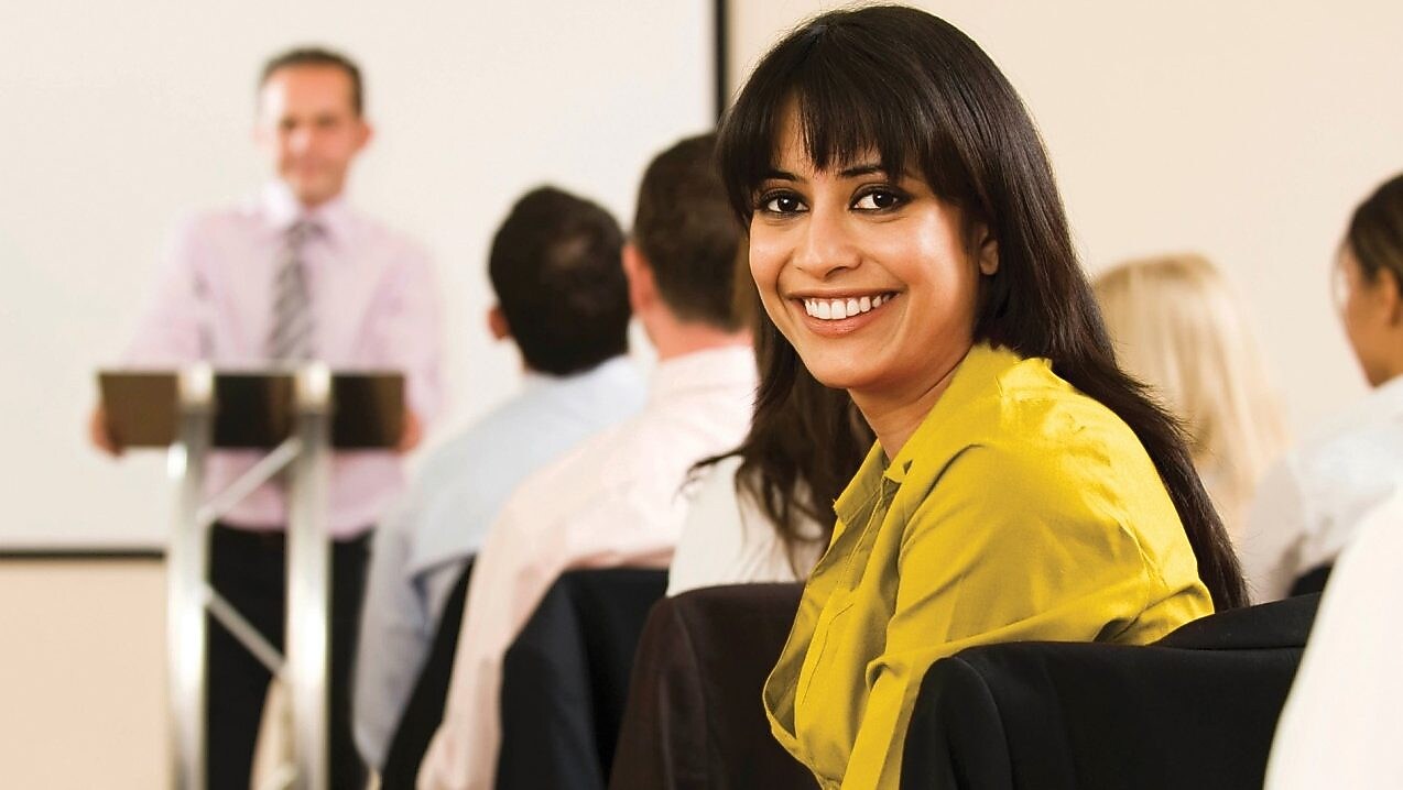 Sonriente mujer con blusa amarilla mirando hacia atrás