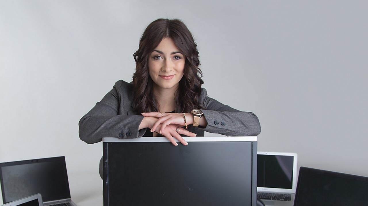 Mujer con computadoras sonriendo