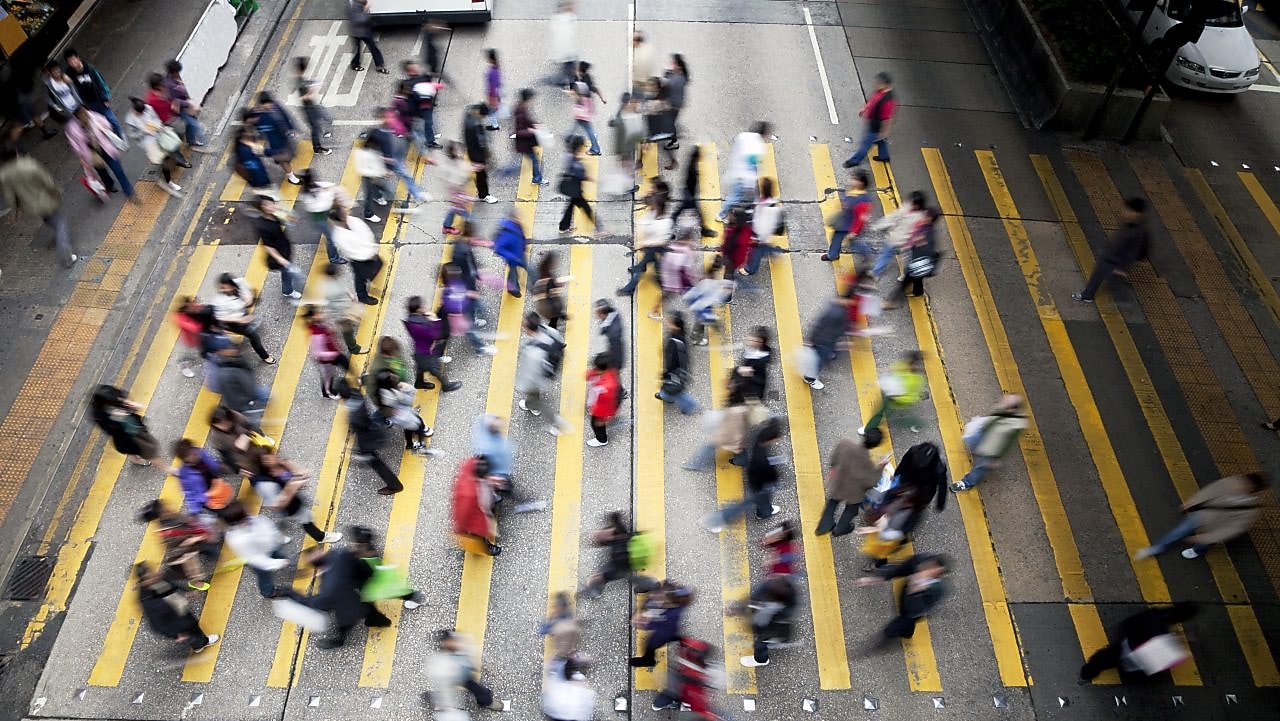 Personas cruzando una calle llena de gente en Hong Kong