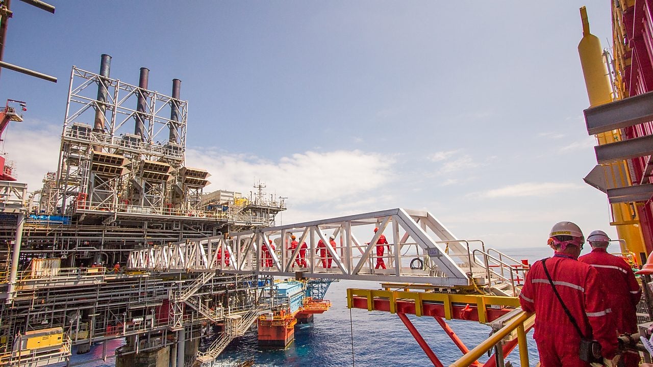 Trabajadores pasan a una nueva plataforma desarrollada junto al proyecto existente en aguas profundas de Malampaya