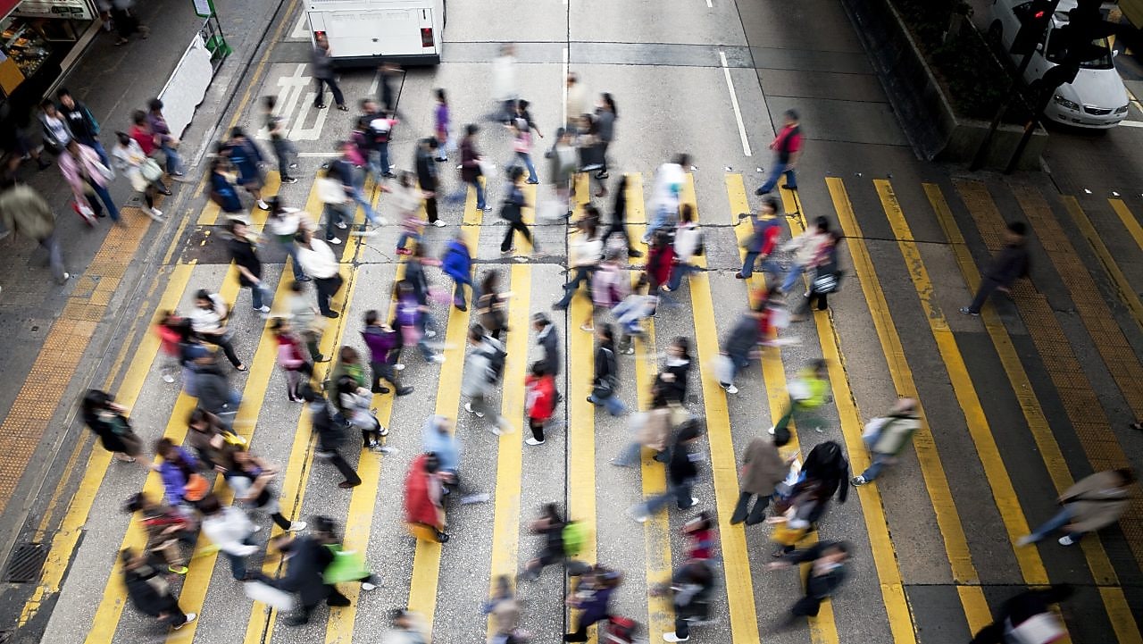 Personas cruzando una calle llena de gente en Hong&nbsp;Kong