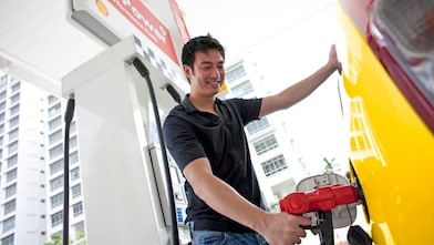 Usuario cargando combustible en una estación de servicio.