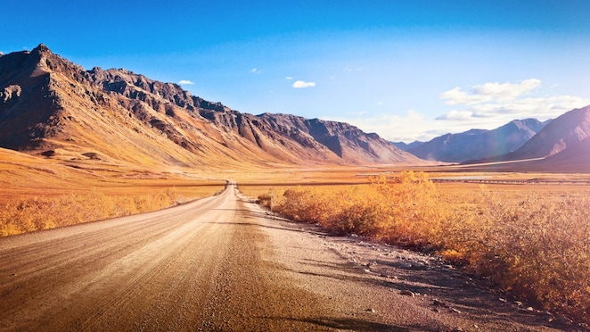 Ruta desierta sin asfaltar rodeada de montañas