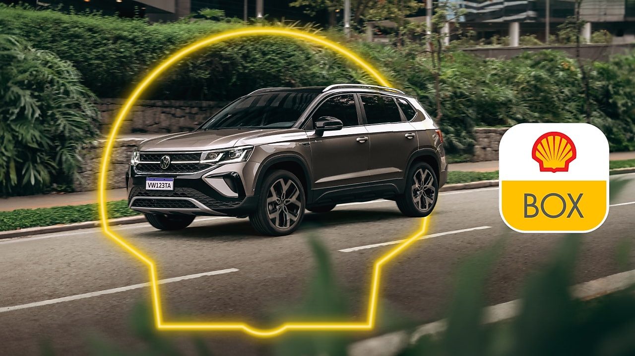 Auto andando por una avenida, se ve el logo de Shell en neón alrededor del auto