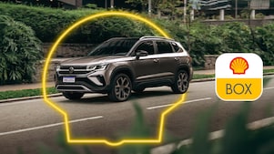 Auto andando por una avenida, se ve el logo de Shell en neón alrededor del auto