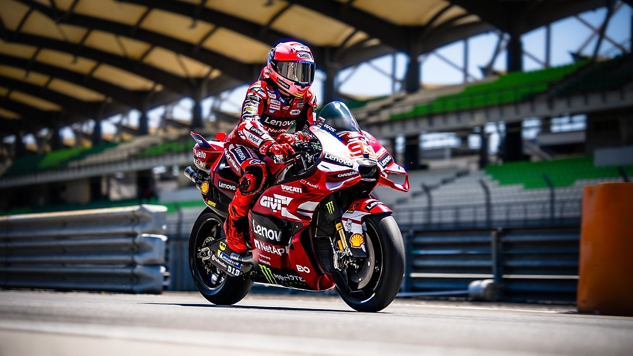 Piloto de Ducati conduciendo una moto a alta velocidad en una pista de noche