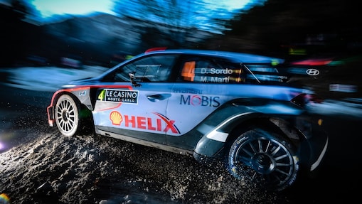 Coche de rally corriendo a gran velocidad al amanecer en el Campeonato del Mundo de Rally