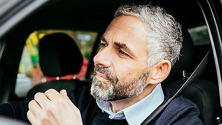 hombre en auto con cinturon de seguridad