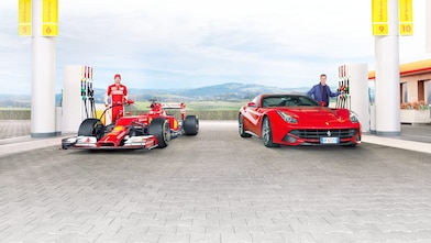 dos automóviles rojos de carreras cargando gasolina