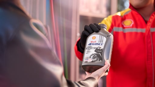 Experto de Shell dando botella de Shell Advance a usuario.