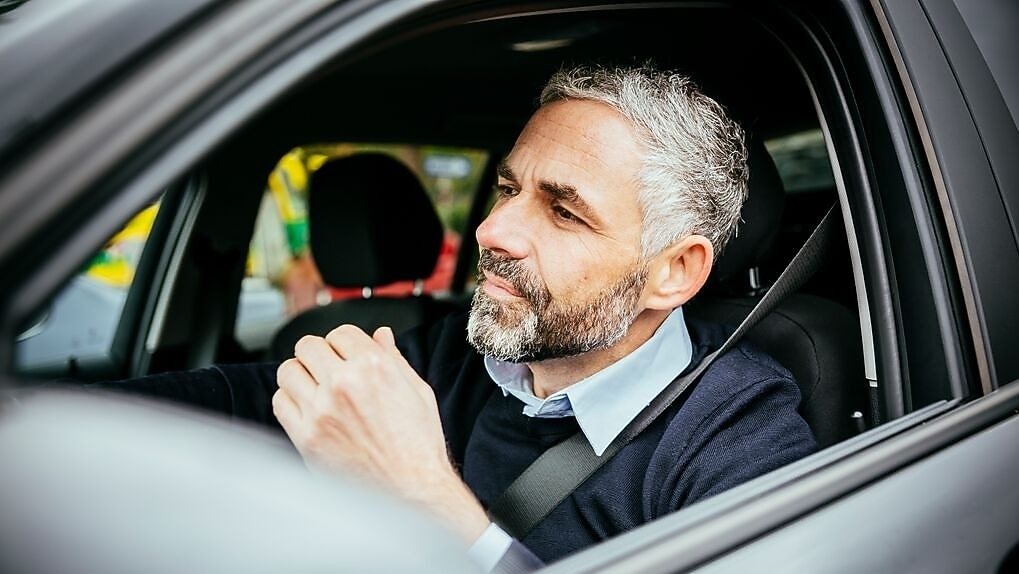 hombre en auto con cinturon de seguridad