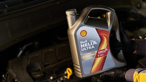 Bidón de lubricante Shell Helix Ultra sostenido por experto de Shell.