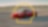Auto Ferrari rojo en movimiento, enmarcado por el logo de Shell
