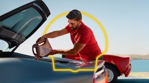 Hombre vertiendo lubricante Shell Helix Ultra en un auto.
