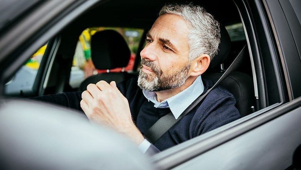 hombre en auto con cinturon de seguridad