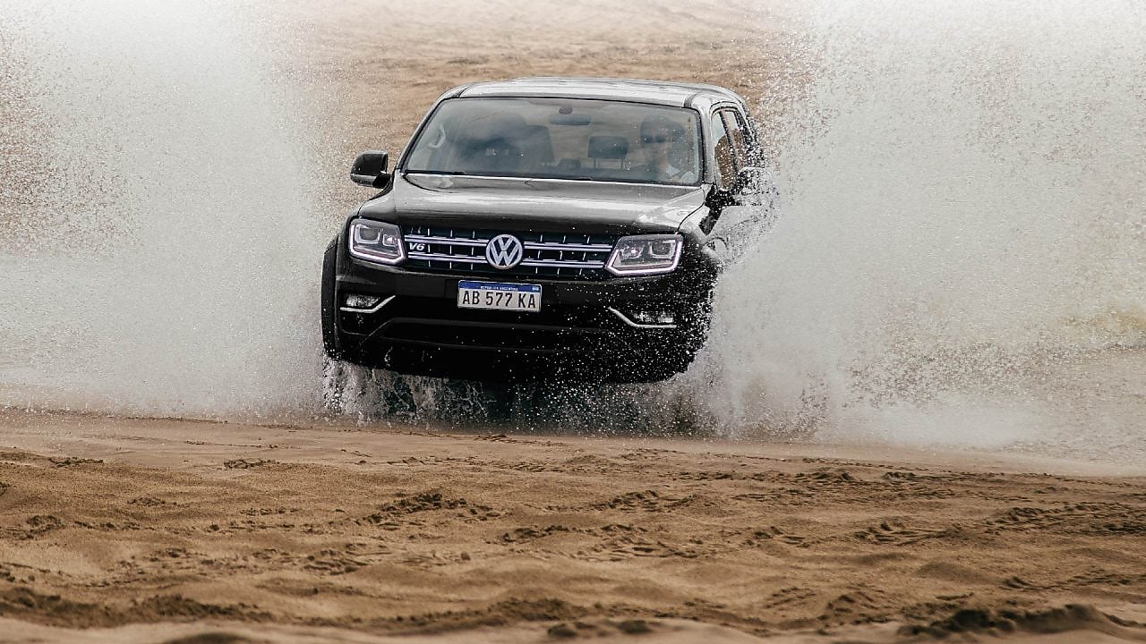 camioneta volkswagen negra surcando el agua velozmente