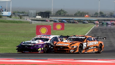Dos autos del Turismo Carretera disputando posición en carrera.
