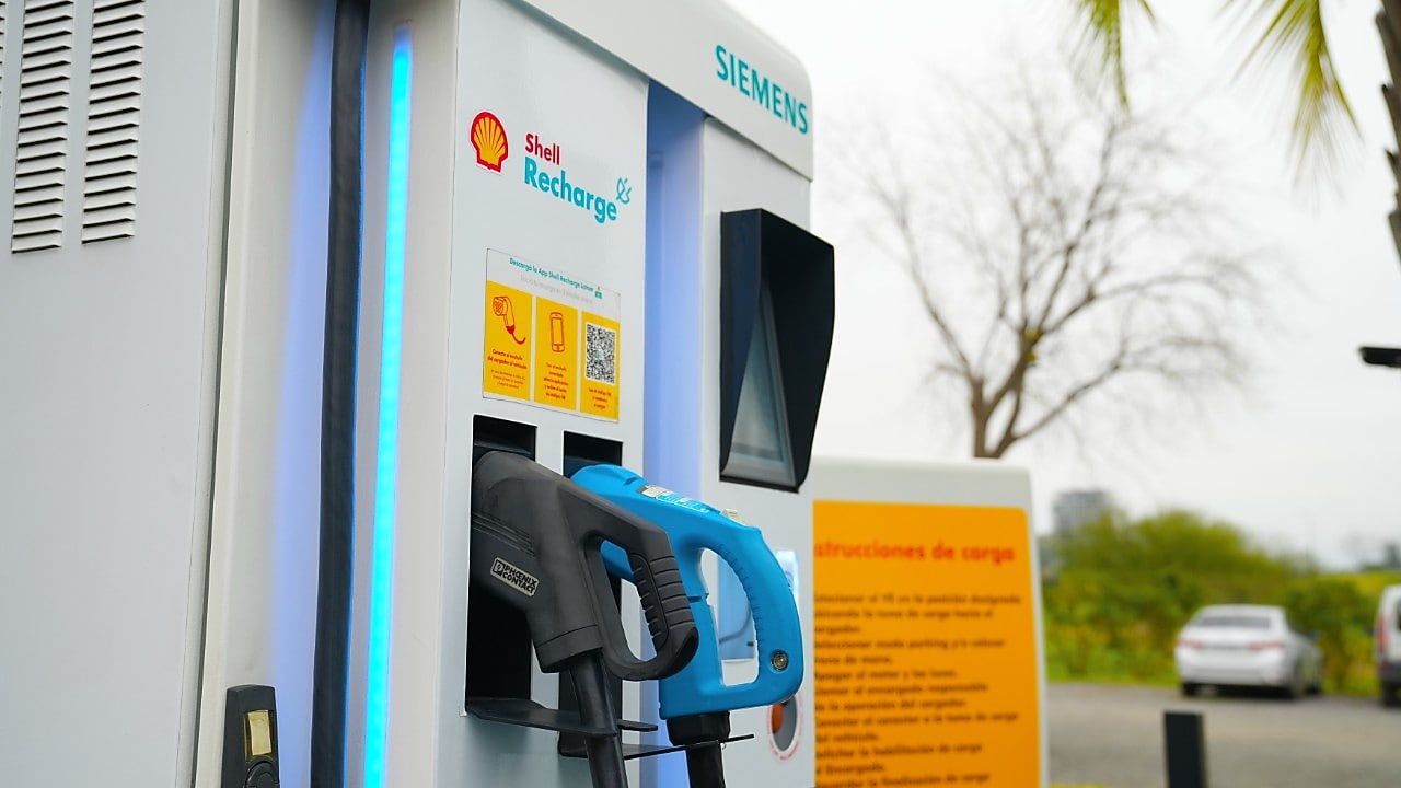 Mano sosteniendo manguera de cargador eléctrico